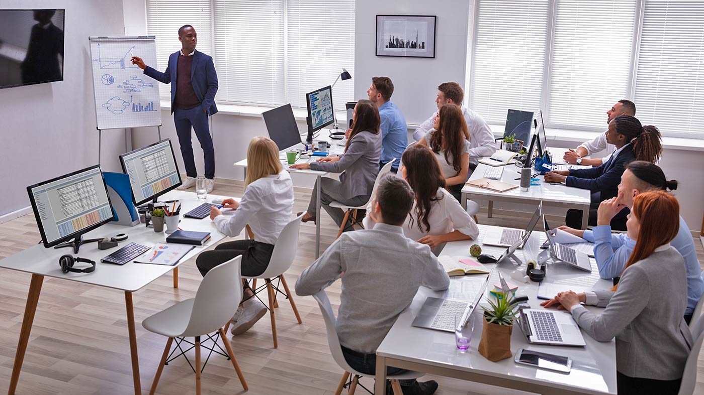 Dozent am Flipchart vor Kursteilnehmern in einem Berufsförderungswerk (Bfw)